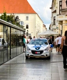 Picture of a sports car driving down a historic street in Hungary