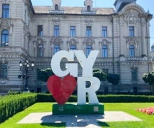 Picture of "I Heart Gyor" sculpture on a green lawn, in front of a historic building
